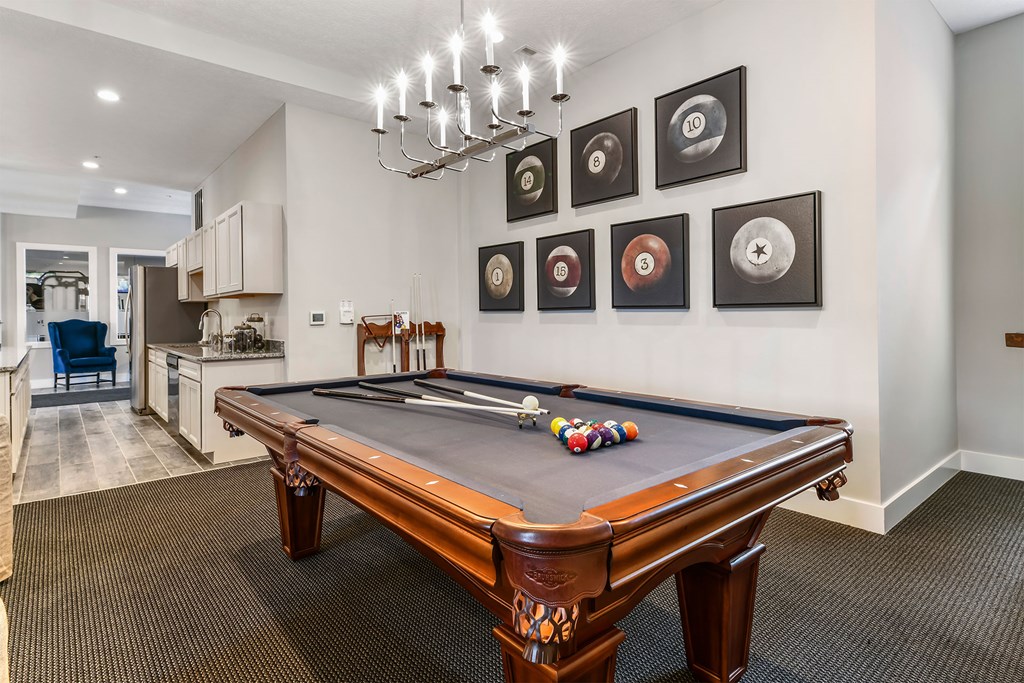A pool table with a brown leather cover and a white cue ball is in the center of the room.