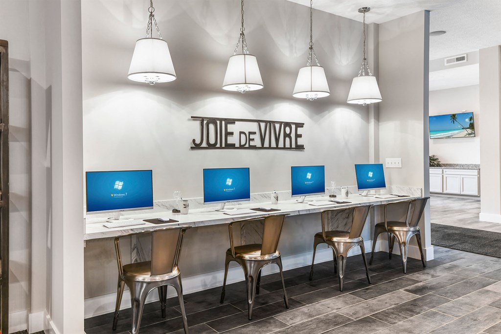 A Joie de Vivre sign is on a wall above a desk with four chairs.