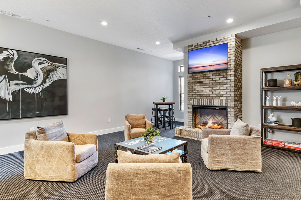A living room with a fireplace and a painting of a bird on the wall.