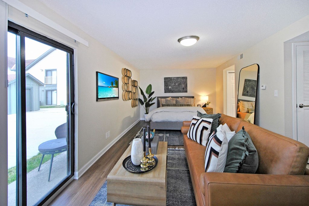 a living room with a couch and a bed in a bedroom