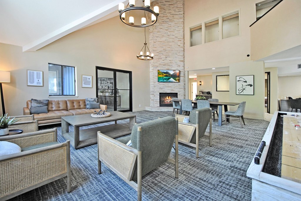 a clubhouse with couches chairs and tables and a fireplace