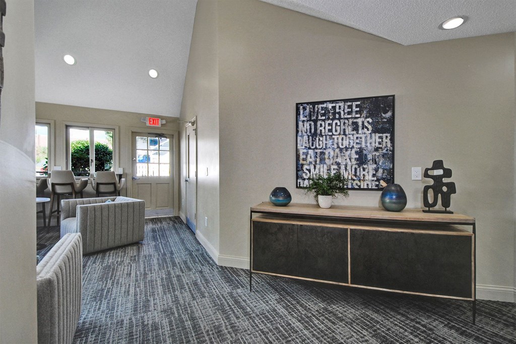 a lobby with couches and a table and a painting on the wall