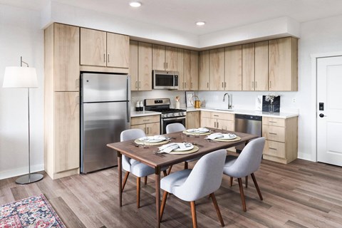 A modern kitchen with a dining table set for two.