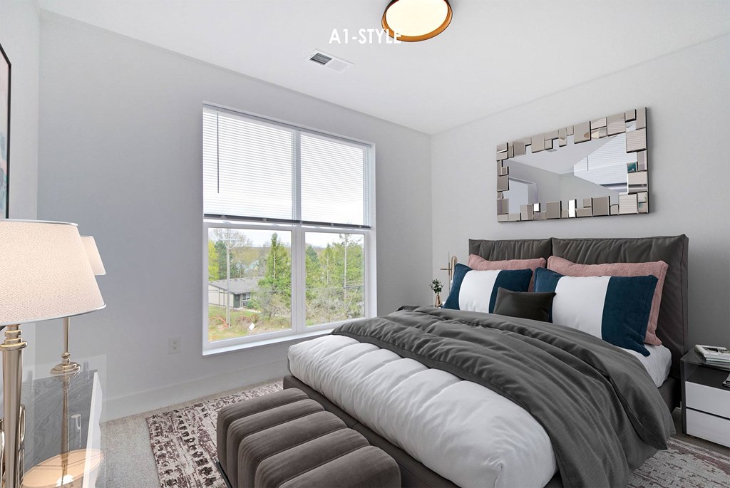 A bedroom with a large bed and a large window.