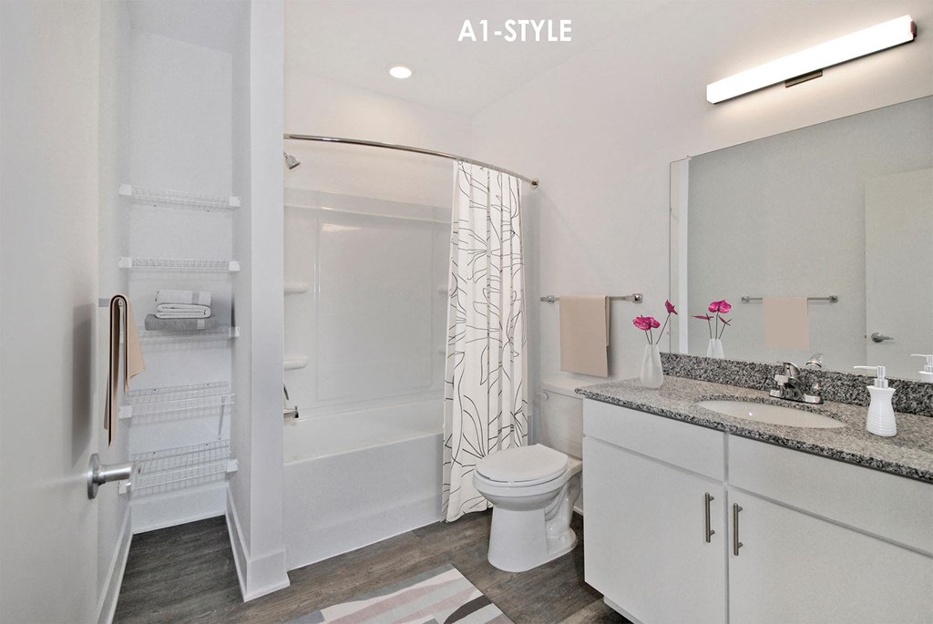 A white bathroom with a toilet, sink, and shower.