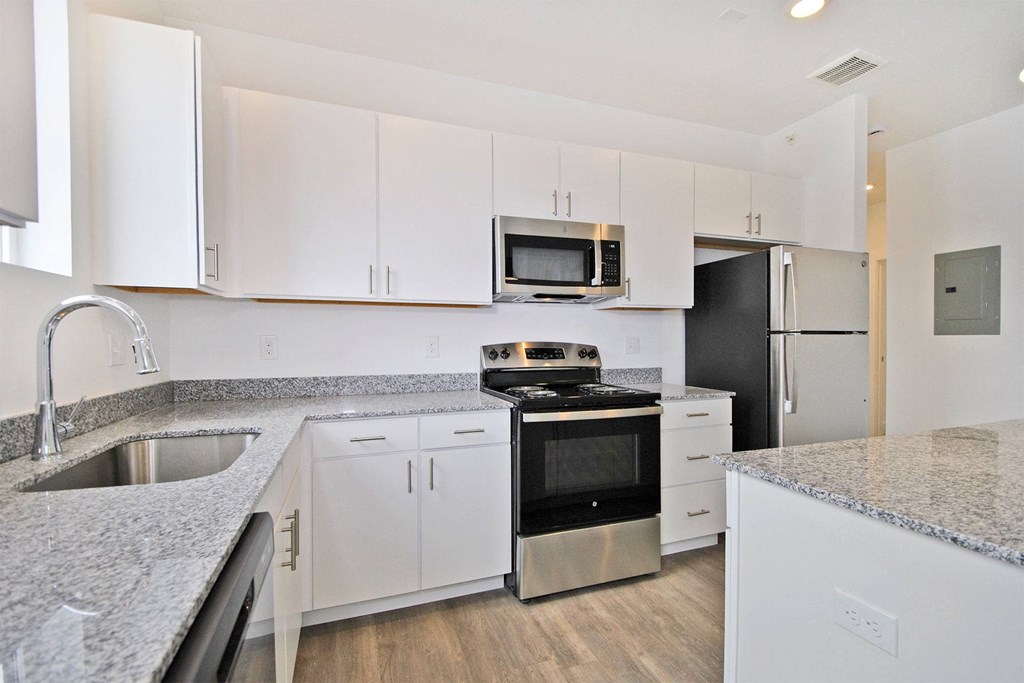 a kitchen with granite counter tops and white cabinets