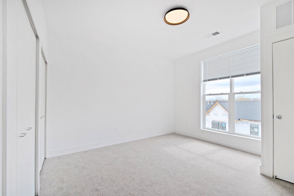 an empty room with a large window and a white door