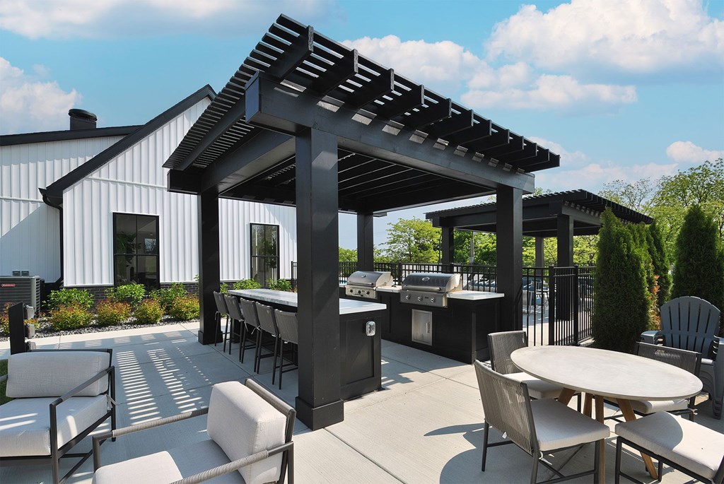 A patio with a table and chairs under a pergola.