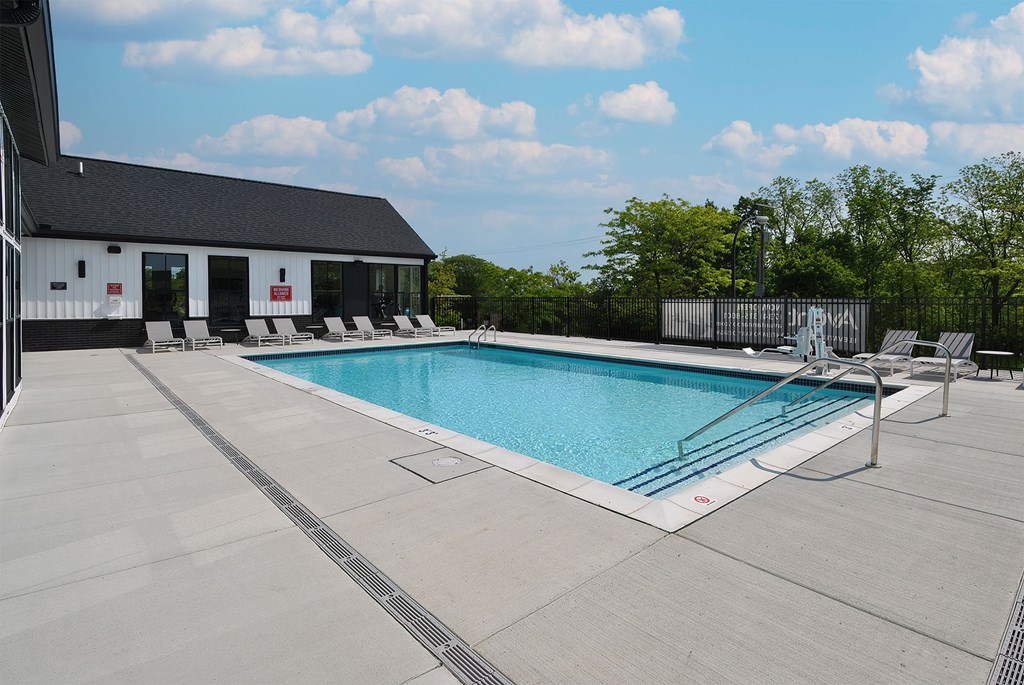 A large outdoor swimming pool with a building in the background.