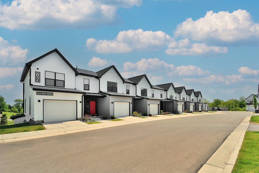 A row of houses with a red door in the middle.