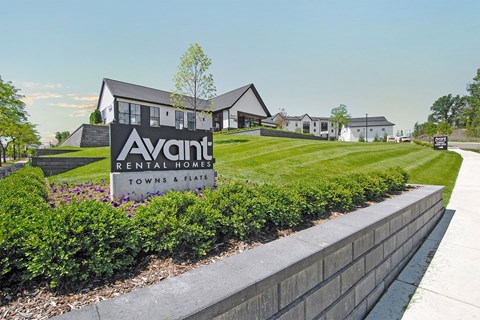 a view of the avanti rental homes sign in front of a grassy yard