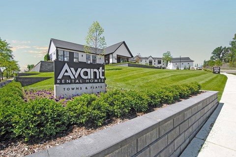 a view of the avanti rental homes sign in front of a grassy yard