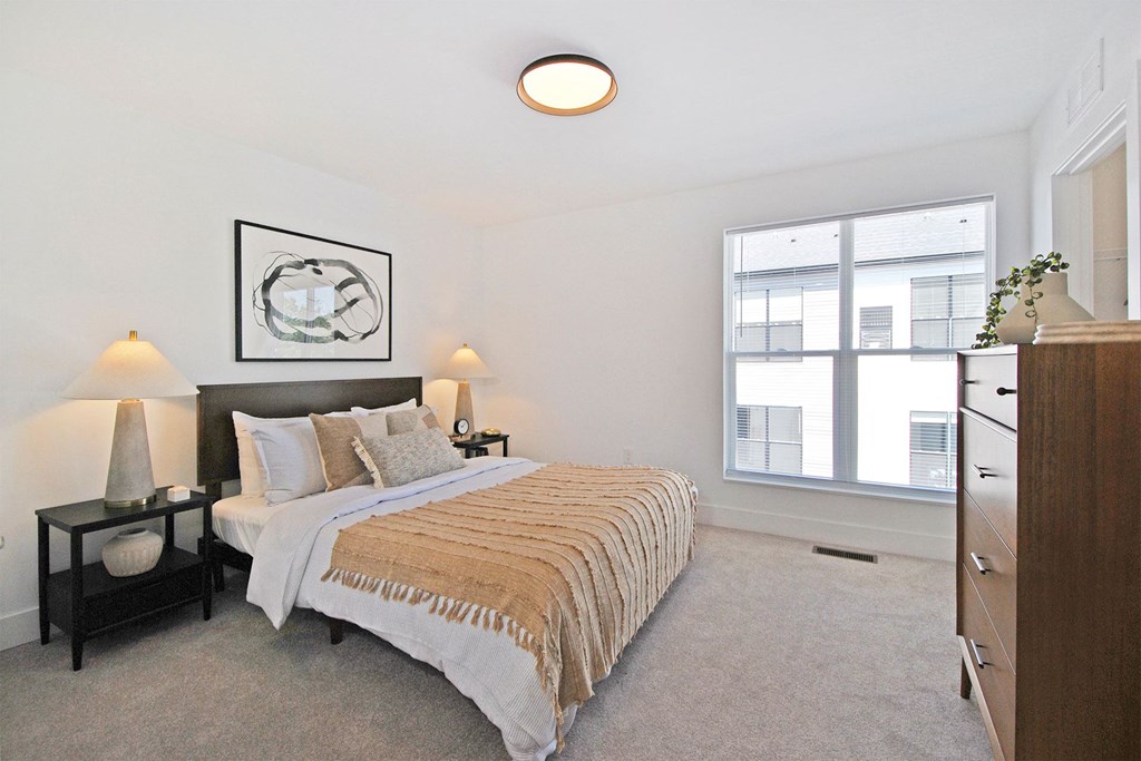 a bedroom with a bed and a large window