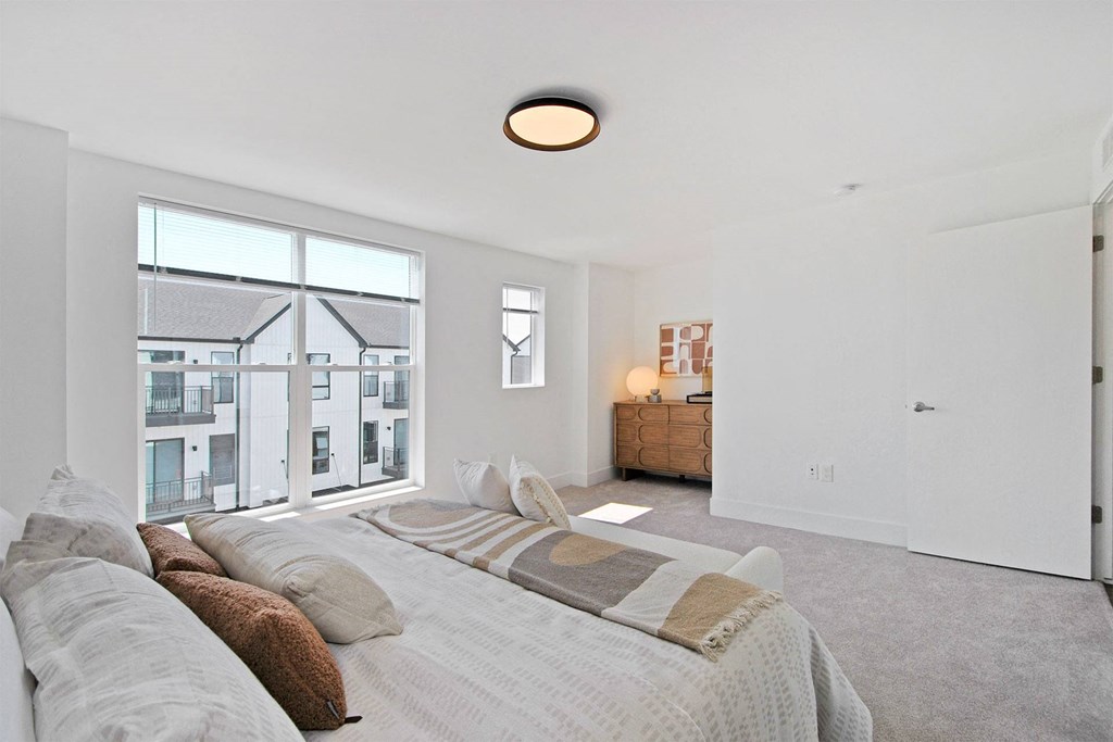 a bedroom with a large bed and a large window