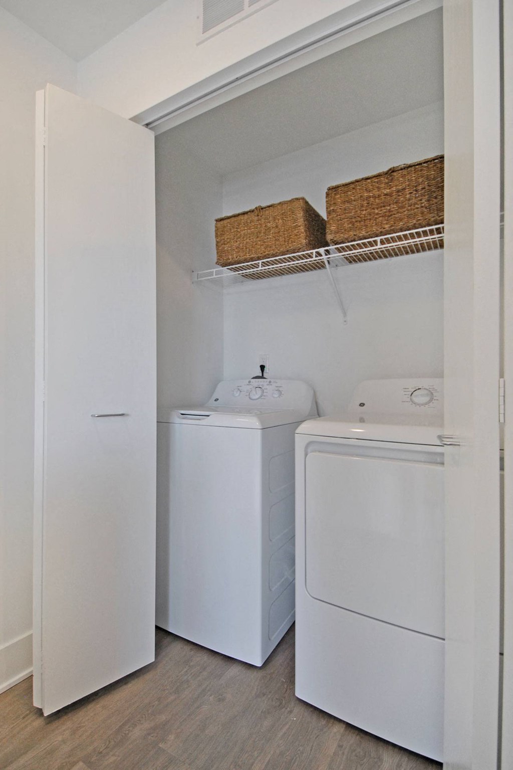 a small laundry room with a white washer and dryer and a white refrigerator