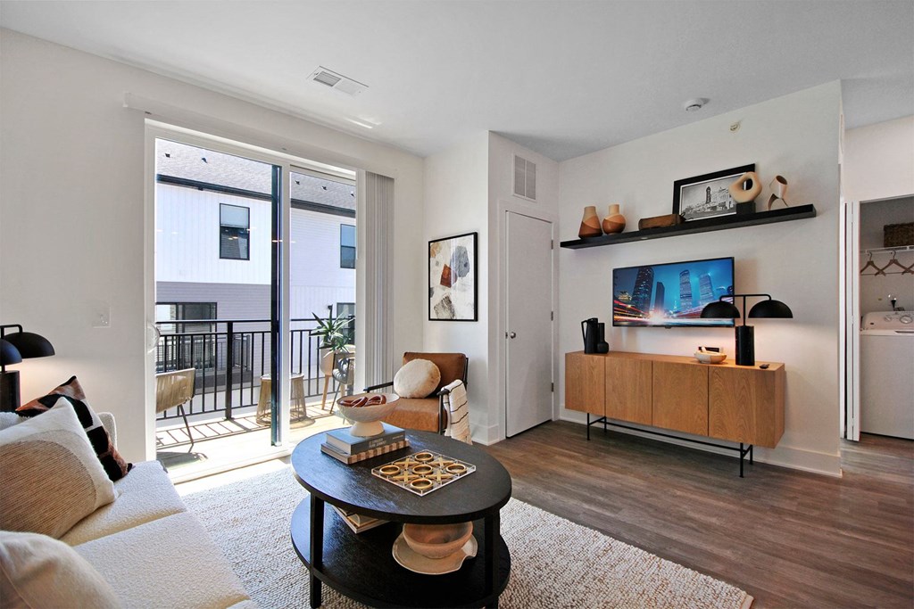 a living room with a door to a balcony and a couch and a table