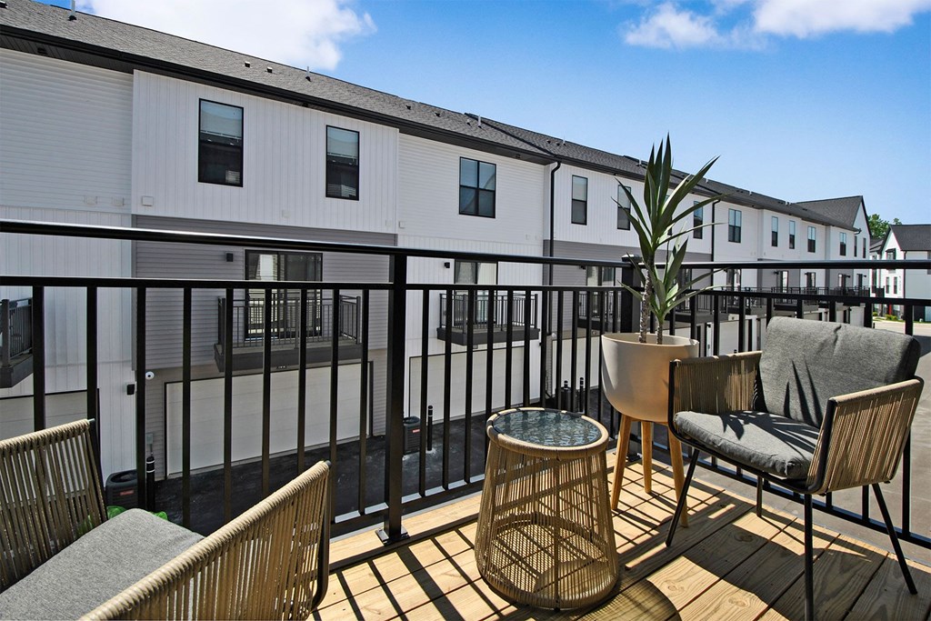 a patio with chairs and tables on a balcony