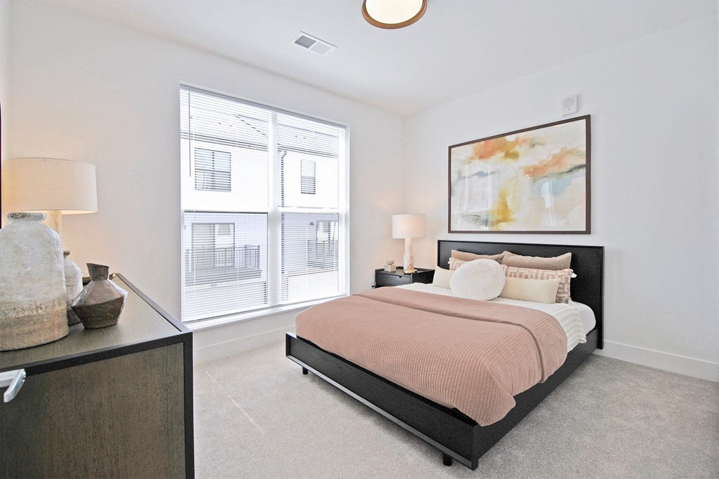 a bedroom with a bed and a large window