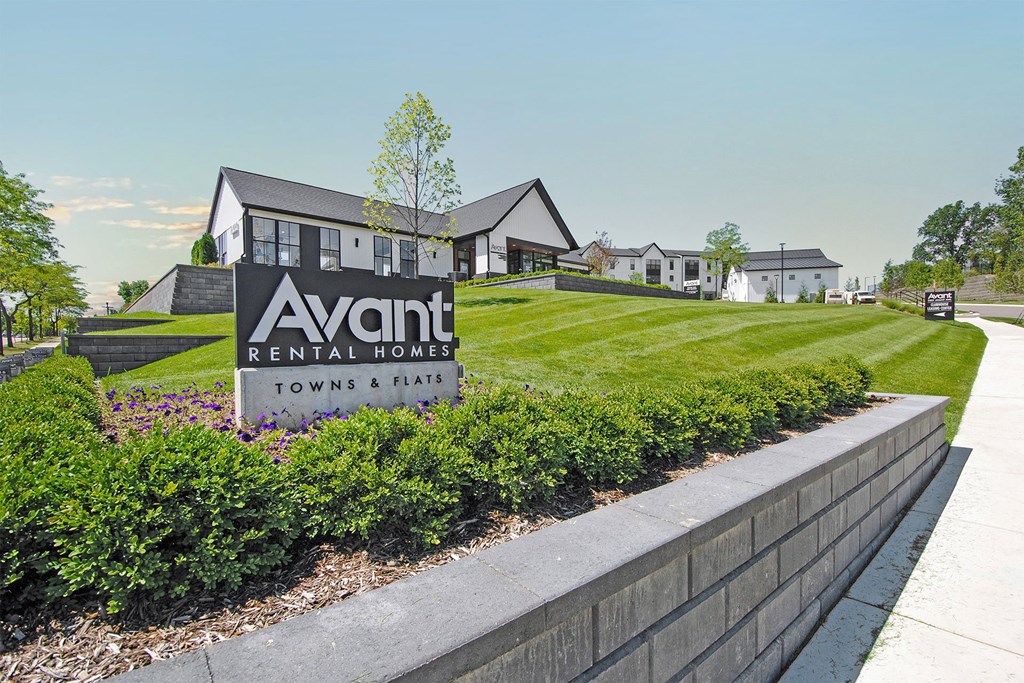 a view of the avanti rental homes sign in front of a grassy yard