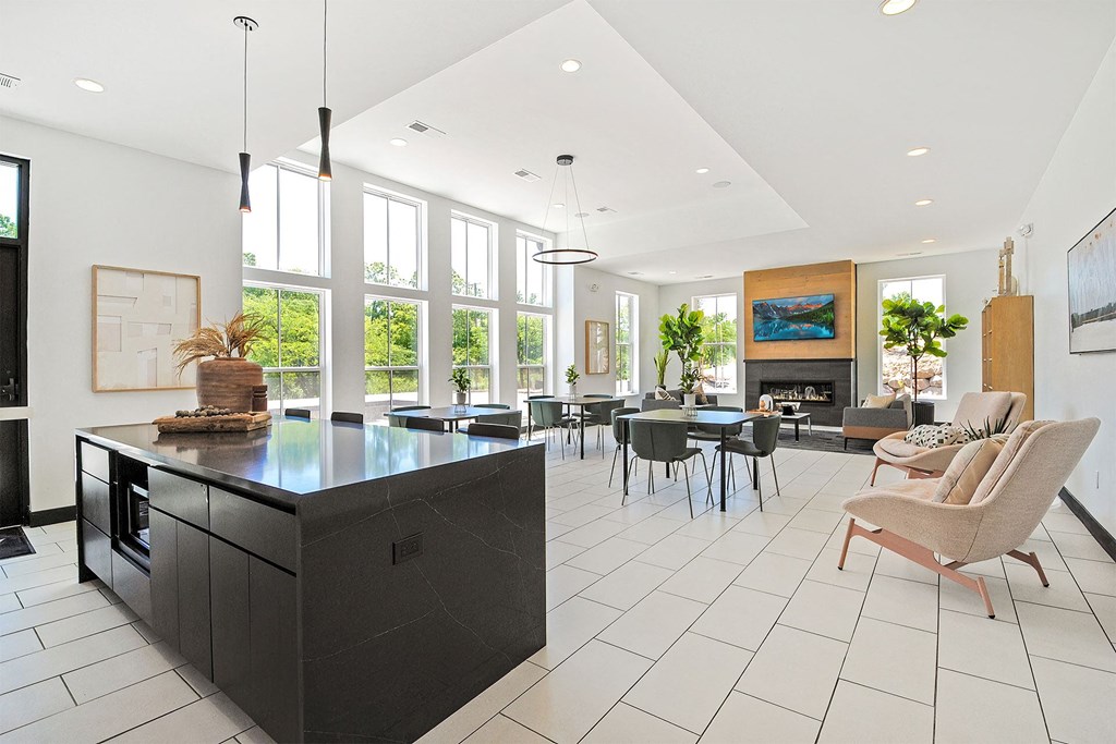 a kitchen with a large island and a living room with a table and chairs