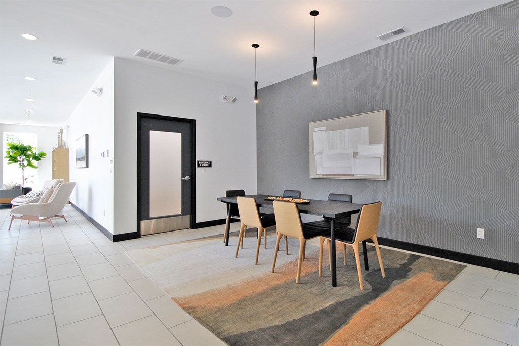 a dining room with a black table and chairs