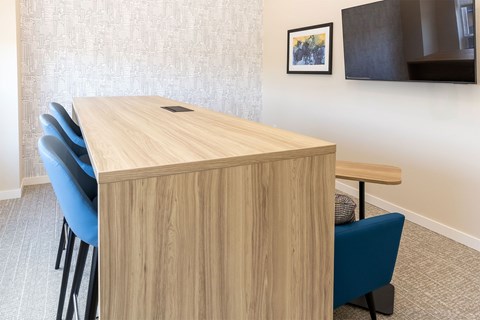 A conference room with a wooden table and blue chairs.