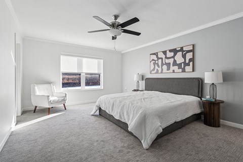 A bedroom with a large bed and a ceiling fan.