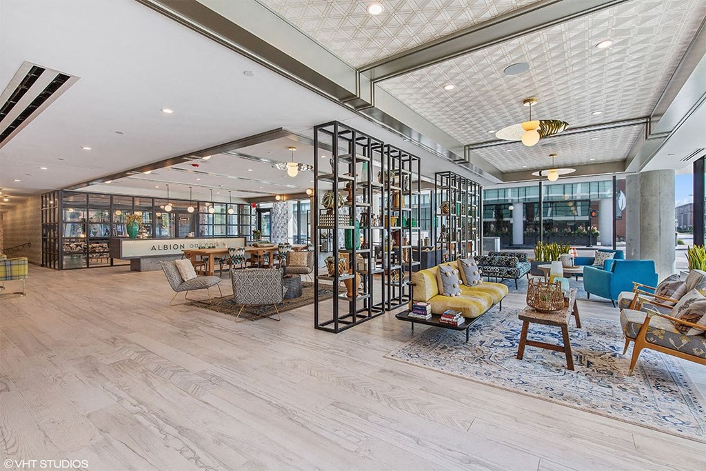 a lobby with furniture and a large glass walled room with tables and chairs