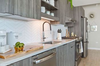 a modern kitchen with stainless steel appliances and wooden cabinets