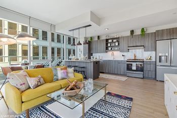 a kitchen and living room with a yellow couch