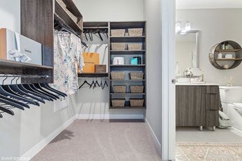 a walk in closet in a bathroom with a closet organizer