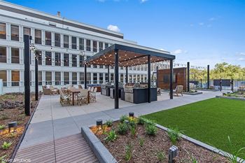 a patio with tables and chairs in front of a building