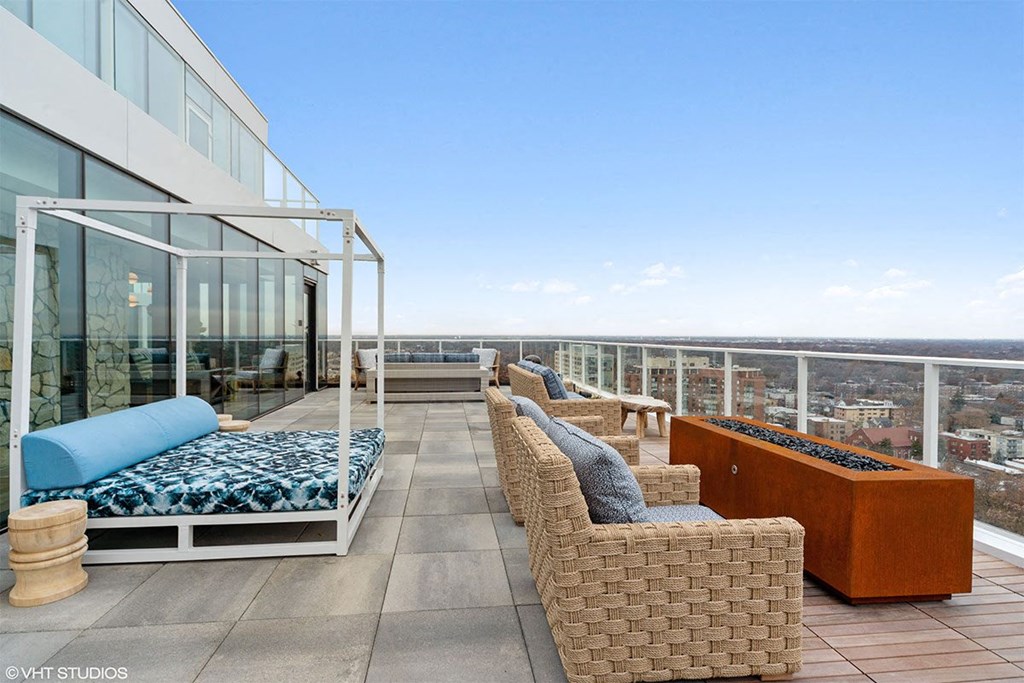 a rooftop terrace with wicker furniture and a view of the city