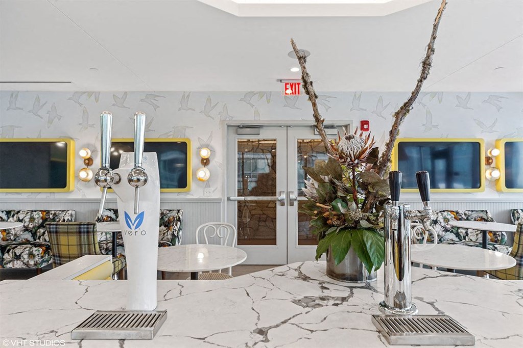 the lobby of a restaurant with tables and a vase of flowers