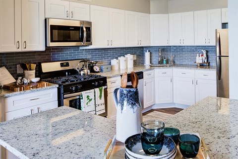 a kitchen with white cabinets and a counter top