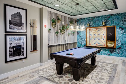a game room with a pool table and a bulletin board