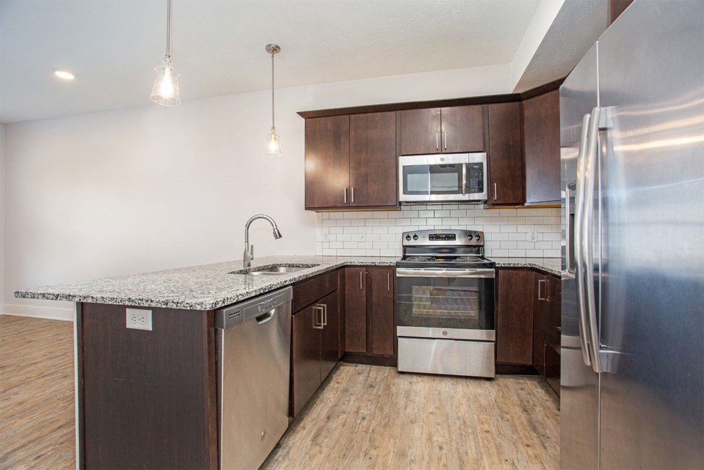 A modern kitchen with wooden cabinets and stainless steel appliances.