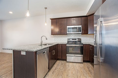 A modern kitchen with wooden cabinets and stainless steel appliances.