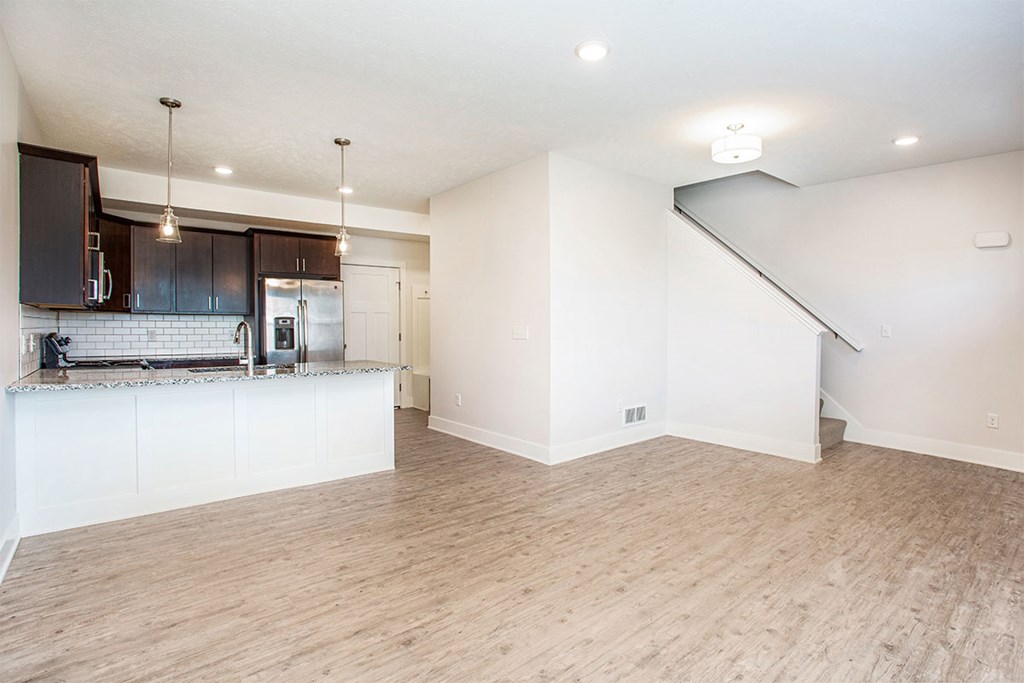 A kitchen with wooden floors and white walls.