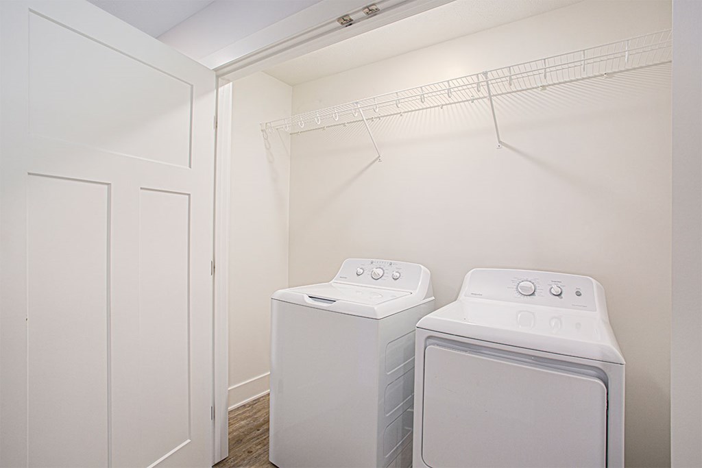 Two white front loading washing machines in a laundry room.