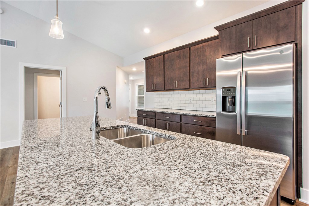 A kitchen with granite countertops and stainless steel appliances.