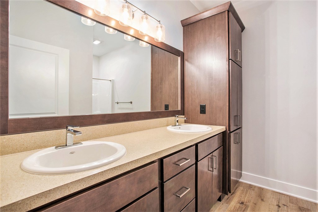 A bathroom with a sink, mirror, and cabinet.