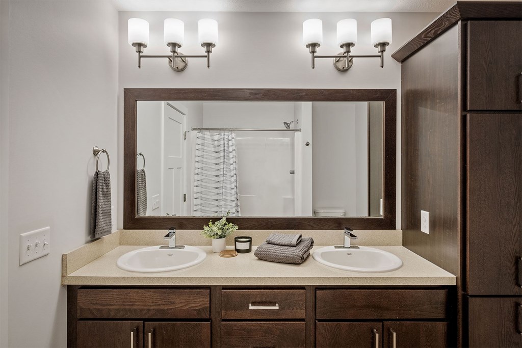 A bathroom with two sinks and a large mirror.