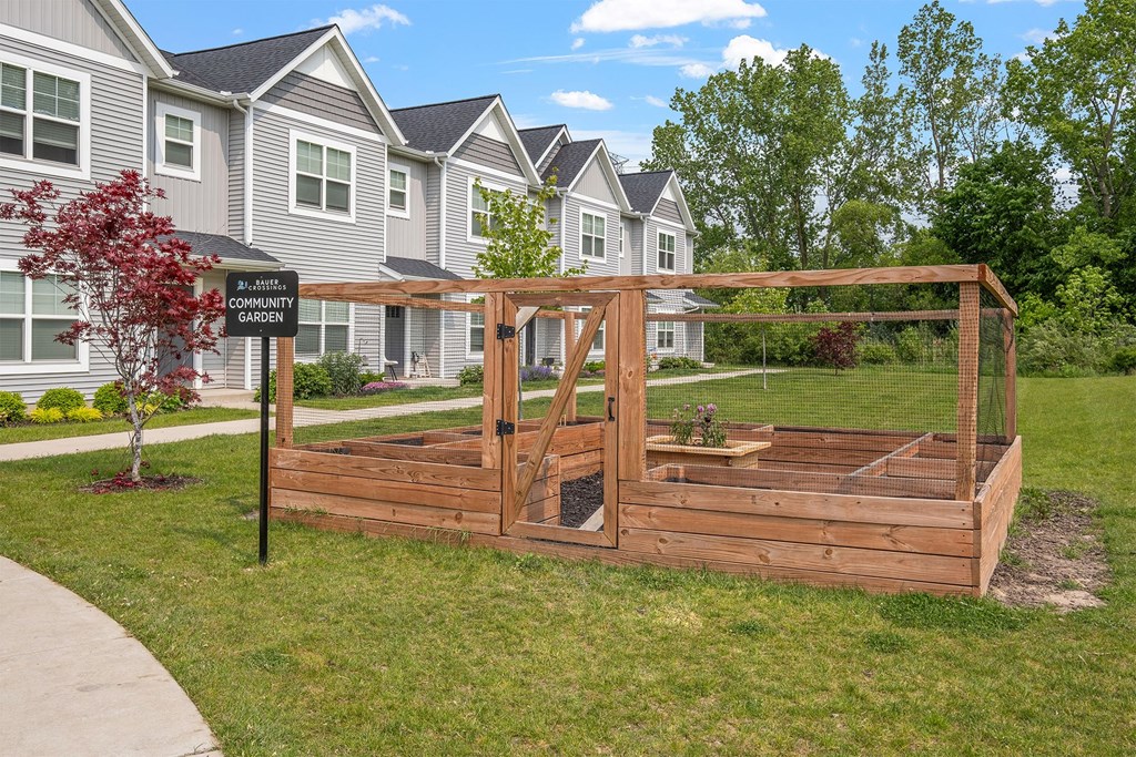 A community garden sign is in front of a building.