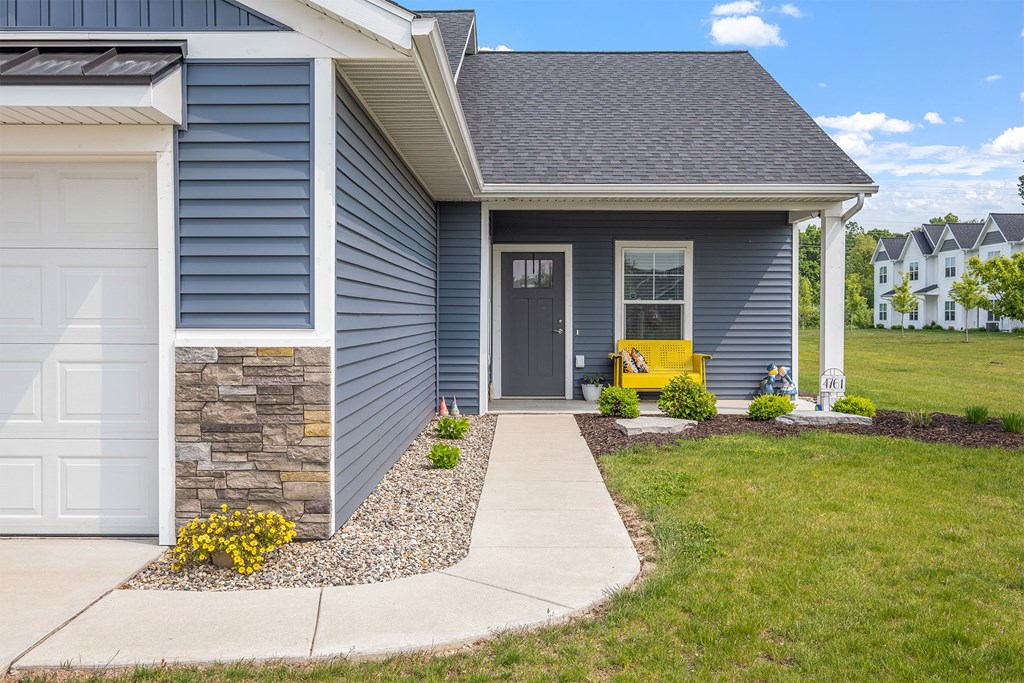 A house with a grey exterior and a white garage door.