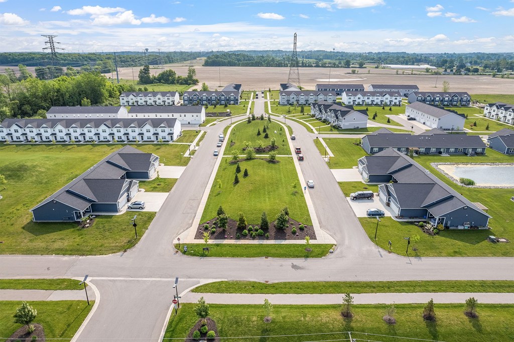 A bird's eye view of a residential area with houses and a road.