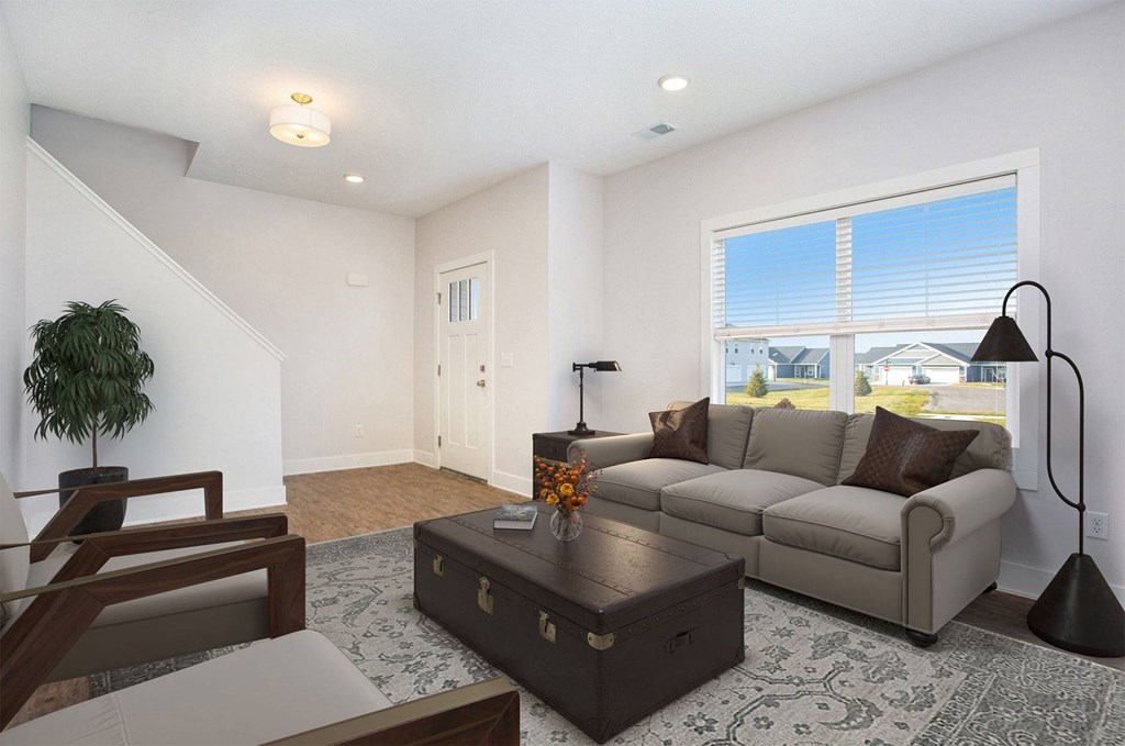 A living room with a brown couch, a coffee table, and a lamp.