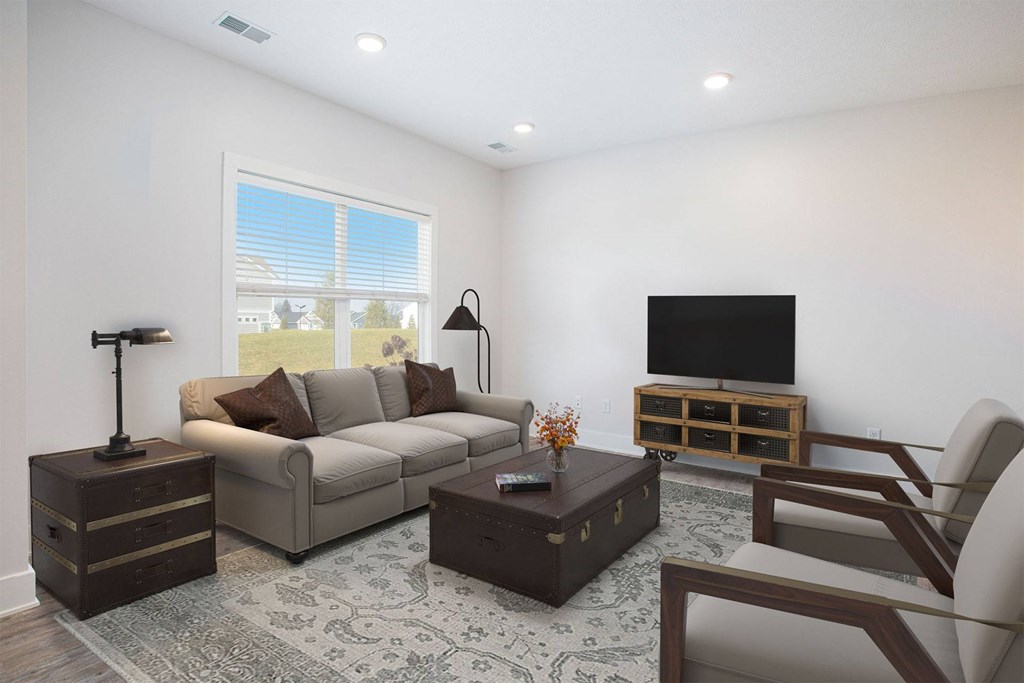 A living room with a couch, coffee table, and television.