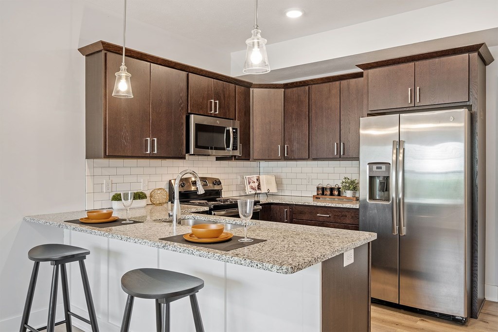 A kitchen with a granite countertop and stainless steel appliances.