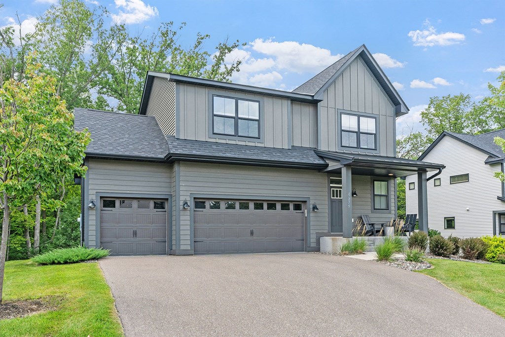 A house with a grey garage door and a grey roof.